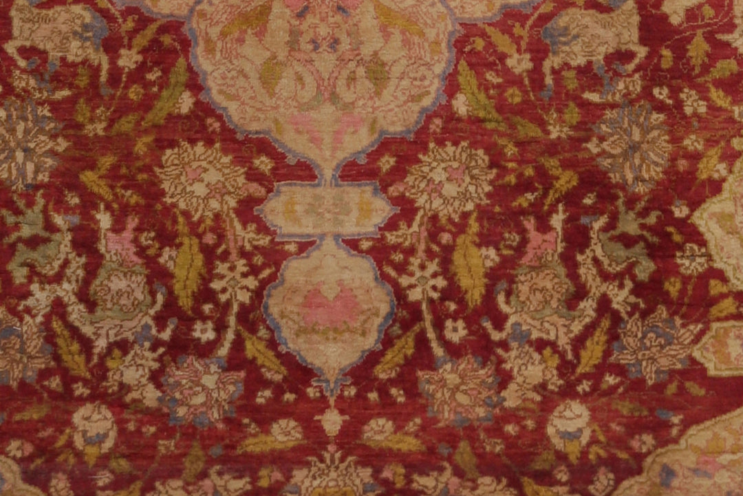 Close-up of a patterned fabric with intricate designs on a red background