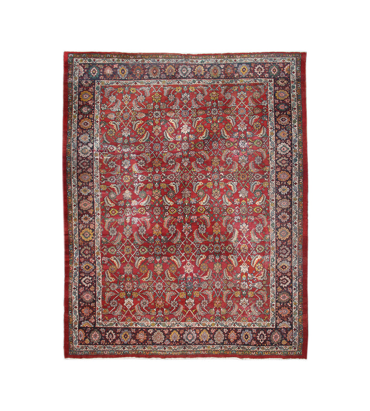 Antique 10x12 Persian Mahal wool rug featuring a red background, blue accent tones, and an allover Herati design with authentic vintage wear.