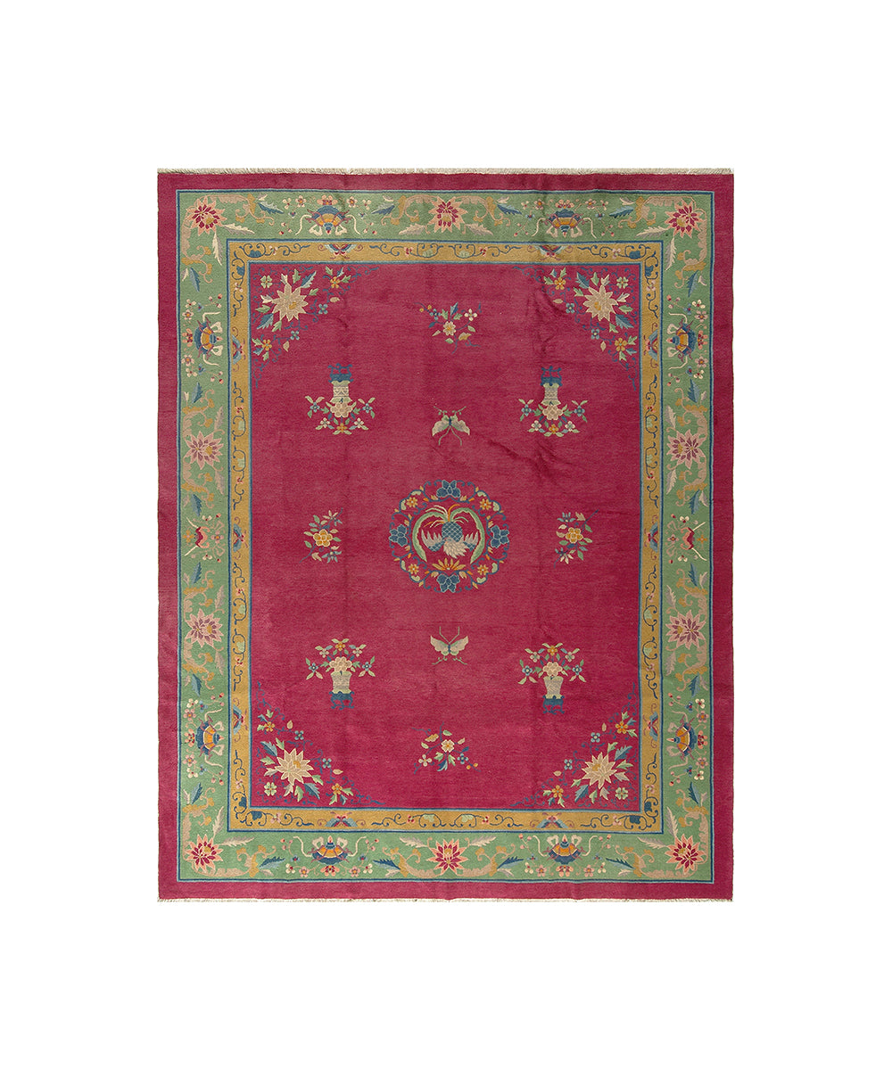 Decorative rug with a red center and colorful border on a white background