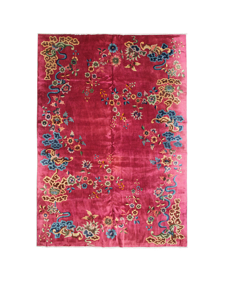 Decorative red rug with colorful floral and animal patterns on a white background