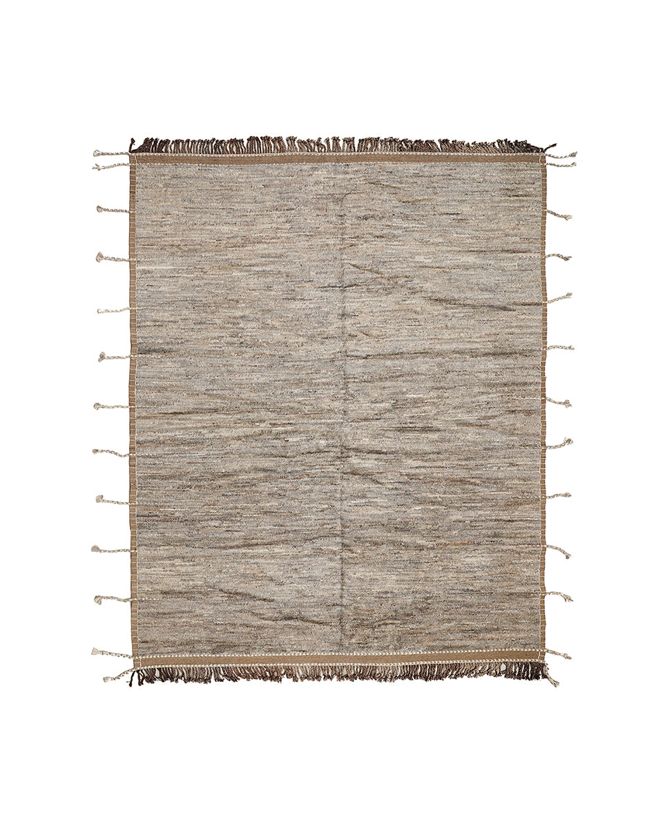 Textured area rug with tassels on a white background