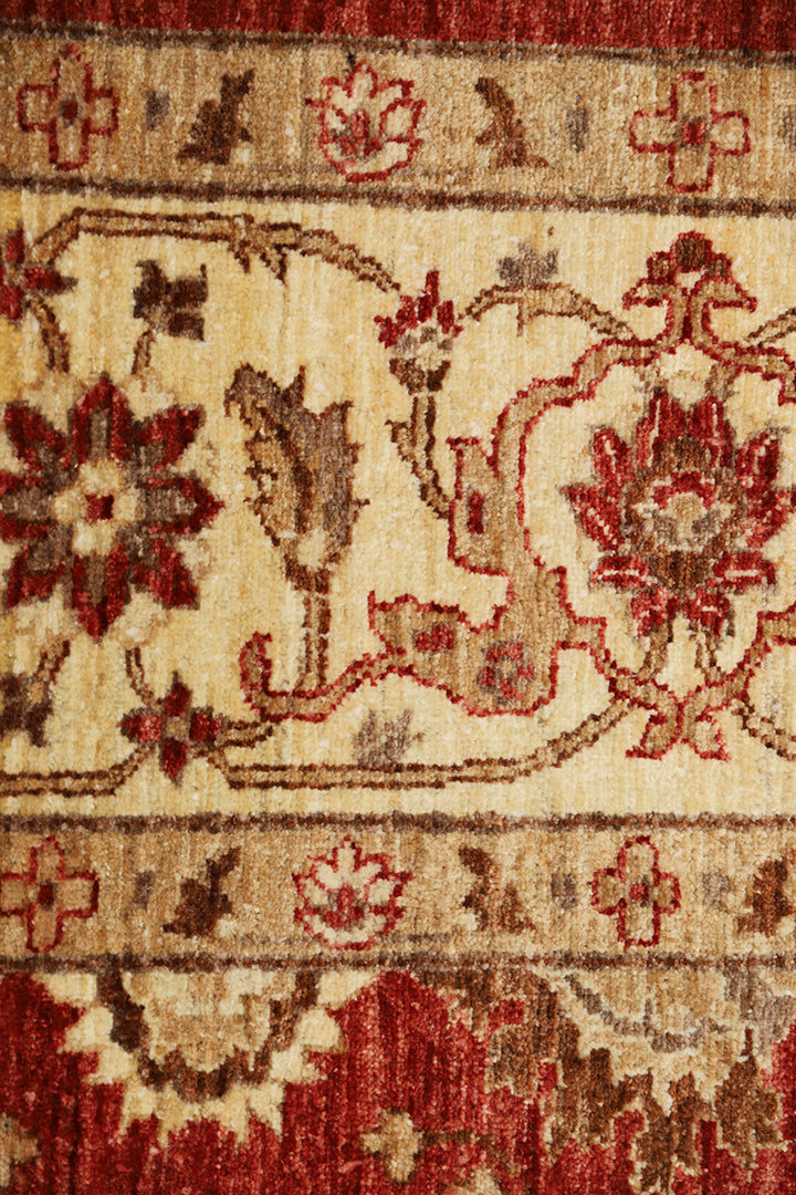 Close-up of a patterned rug with red and beige colors