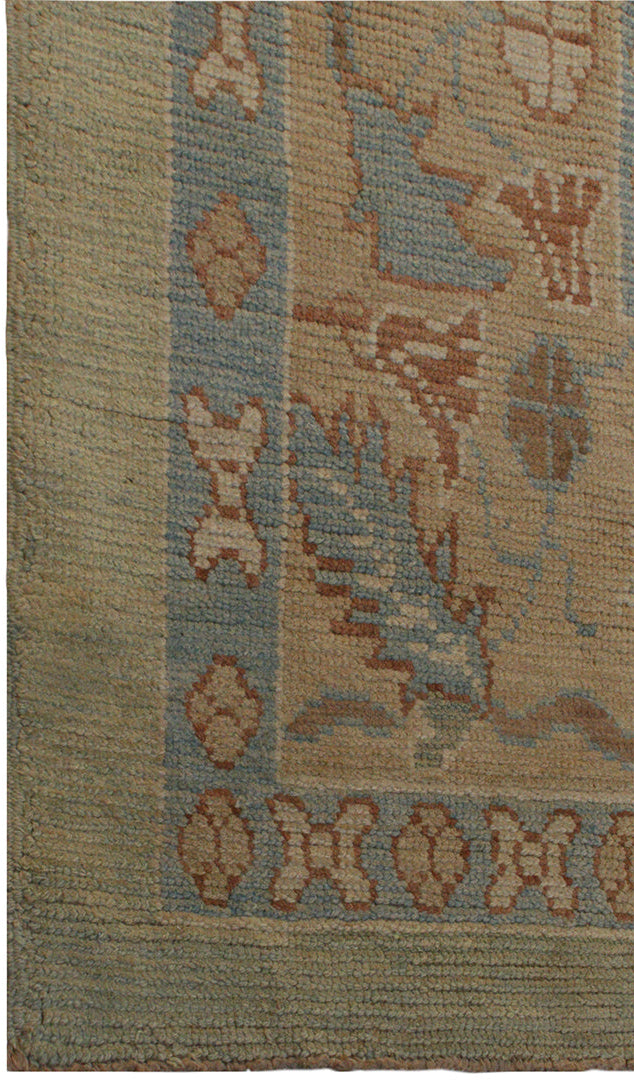 Close-up of a patterned rug with geometric designs in brown, blue, and beige.
