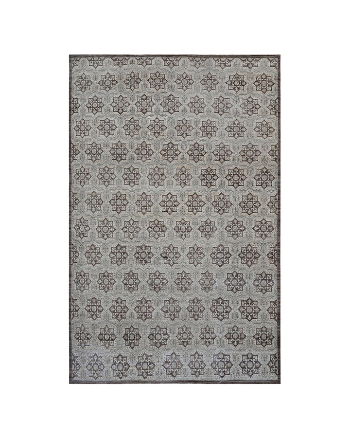 A rectangular area rug with a repeating geometric medallion pattern in gray and brown tones, shown flat against a white background.