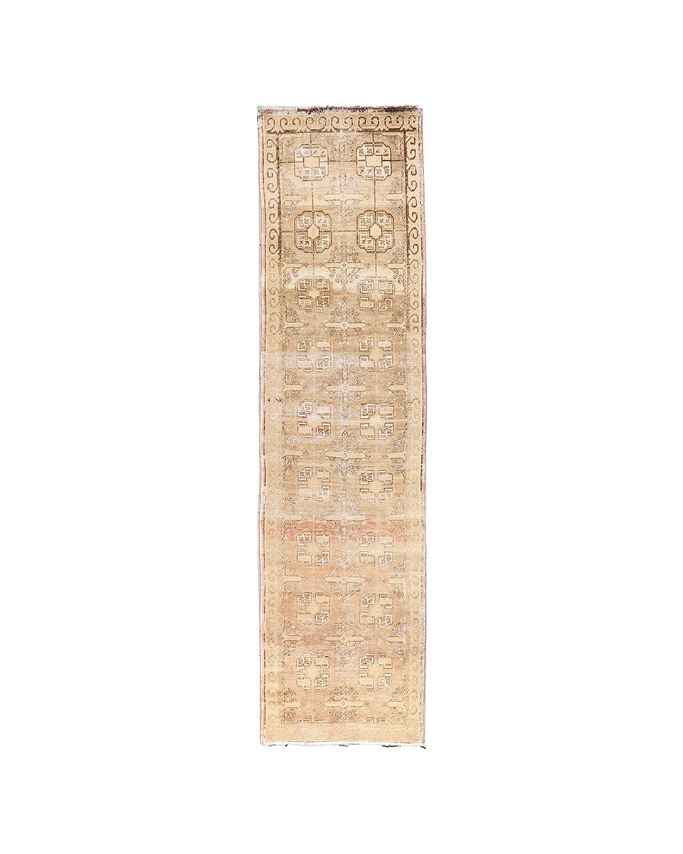 Beige runner rug with geometric pattern on a white background