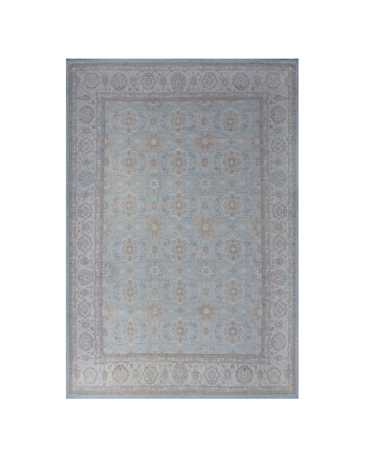 A rectangular area rug with a traditional medallion pattern in muted shades of blue, beige, and gray, shown flat against a white background.