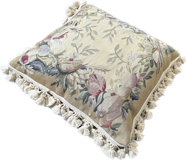 Handcrafted 18x18 cream and tan wool needlepoint cushion with botanical bird motifs and white tassel fringe by Ariana Rugs