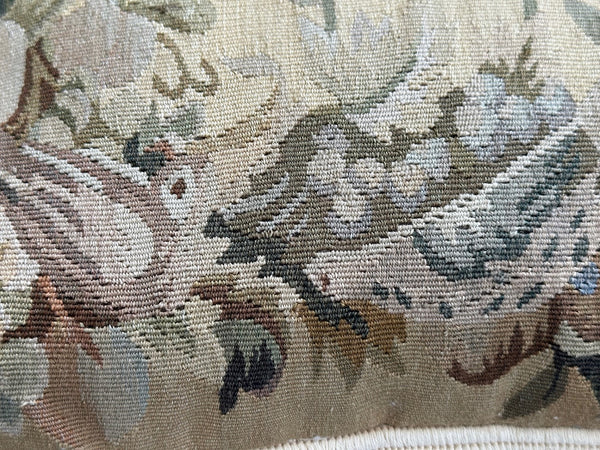 Handcrafted 18x18 cream and tan wool needlepoint cushion with botanical bird motifs and white tassel fringe by Ariana Rugs