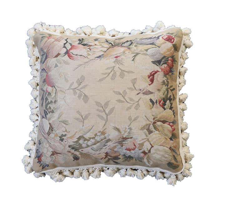 Handcrafted 18x18 cream and tan wool needlepoint cushion with botanical bird motifs and white tassel fringe by Ariana Rugs