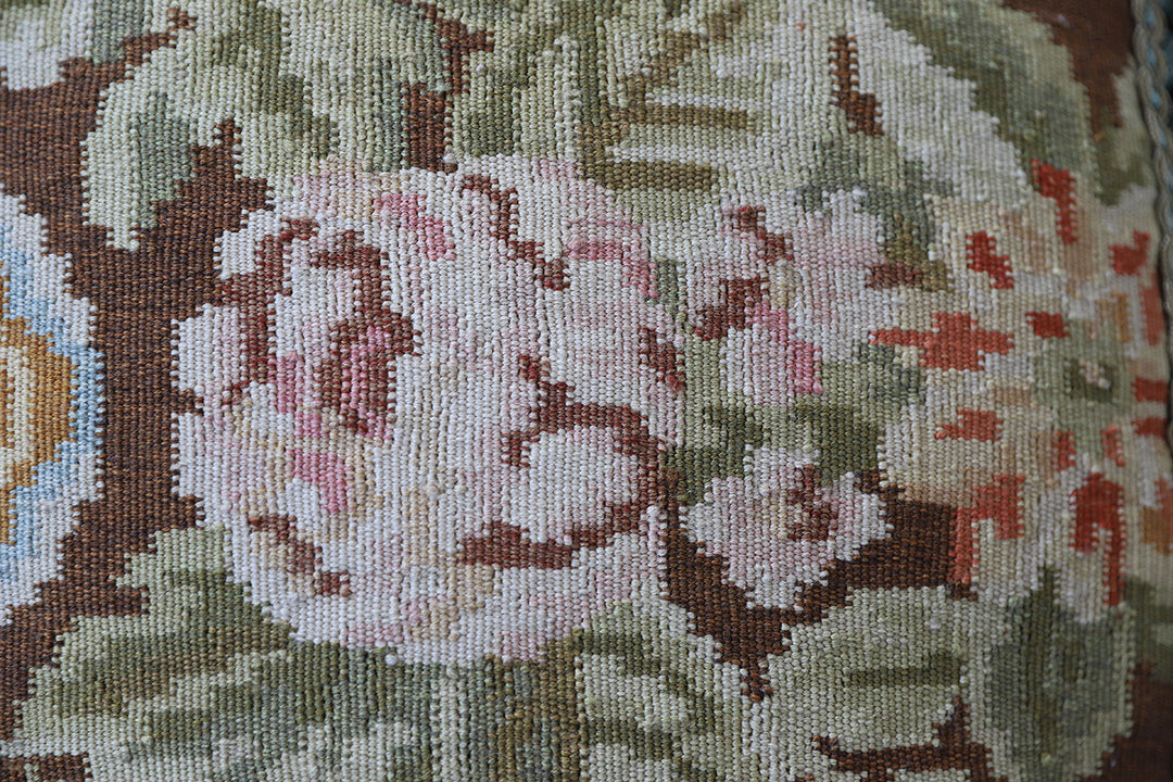 Handcrafted 18x21 brown floral wool accent cushion with white decorative tassels by Ariana Rugs.