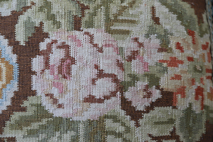 Handcrafted 18x21 brown floral wool accent cushion with white decorative tassels by Ariana Rugs.