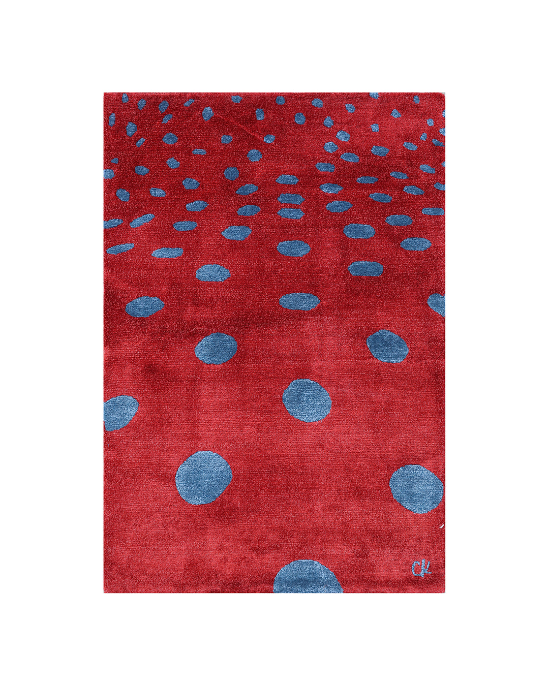 Red rug with blue polka dots on a white background