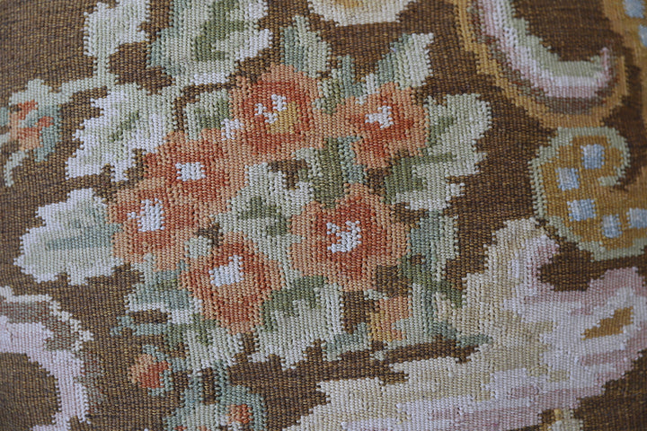 Handwoven brown floral wool cushion cover in warm earth tones by Ariana Rugs.