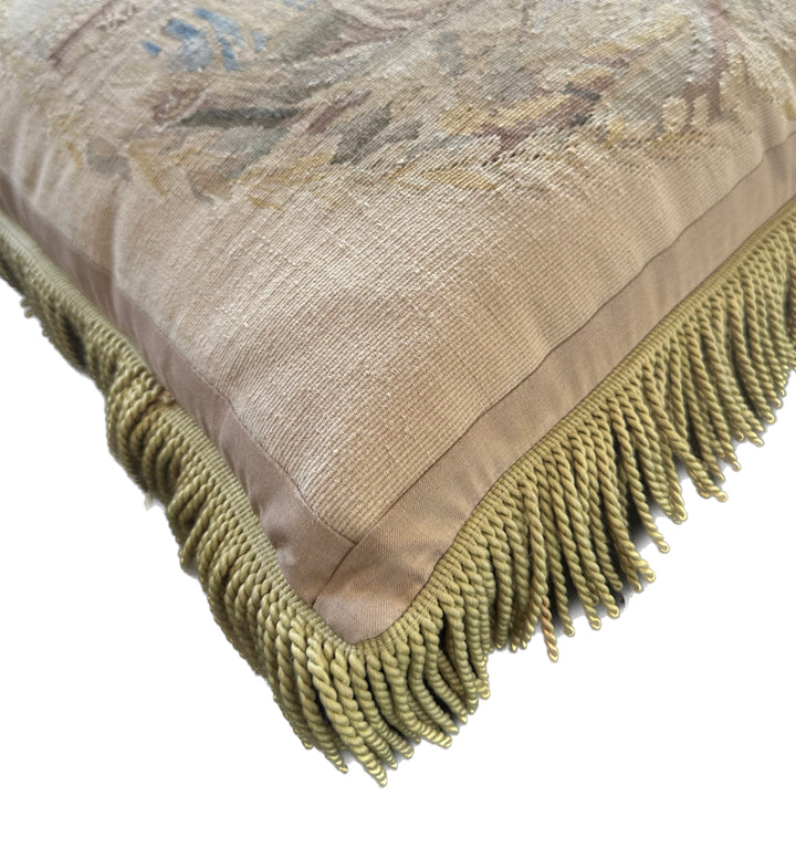 Handcrafted 24x24 beige and blue wool Aubusson style cushion featuring a whimsical animal motif and vibrant green fringe tassels by Ariana Rugs
