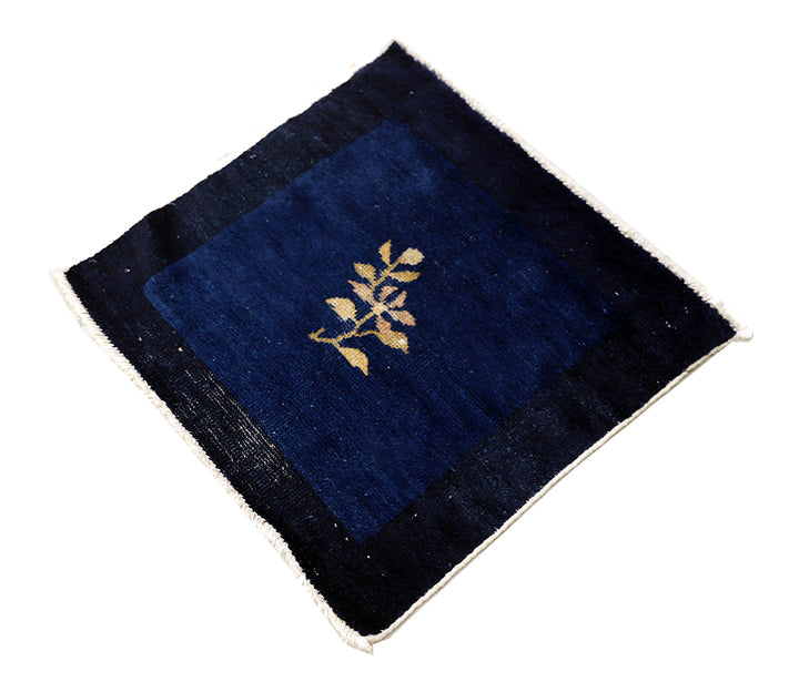 Navy blue fabric square with gold leaf design on a white background