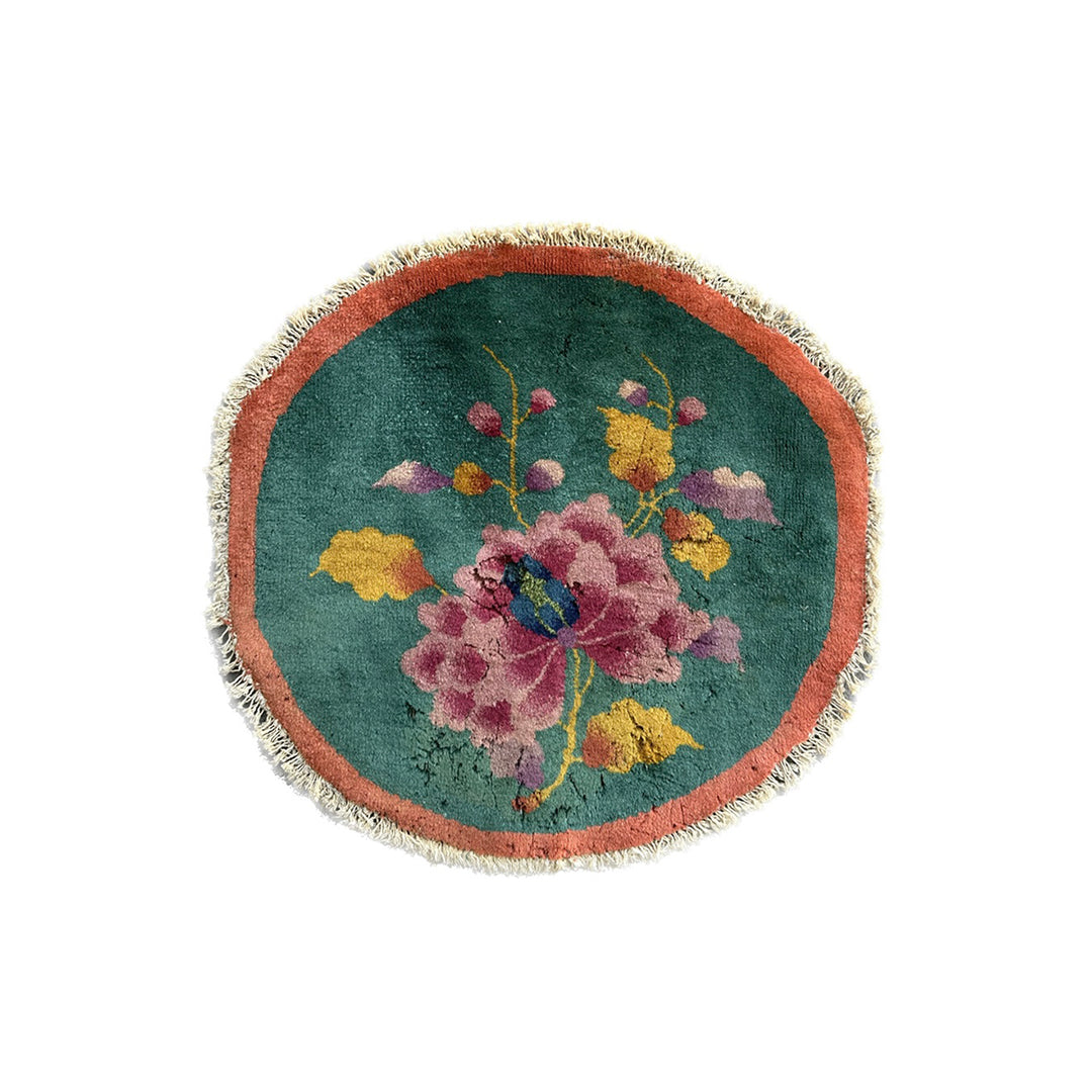 Round embroidered rug with floral design on a white background