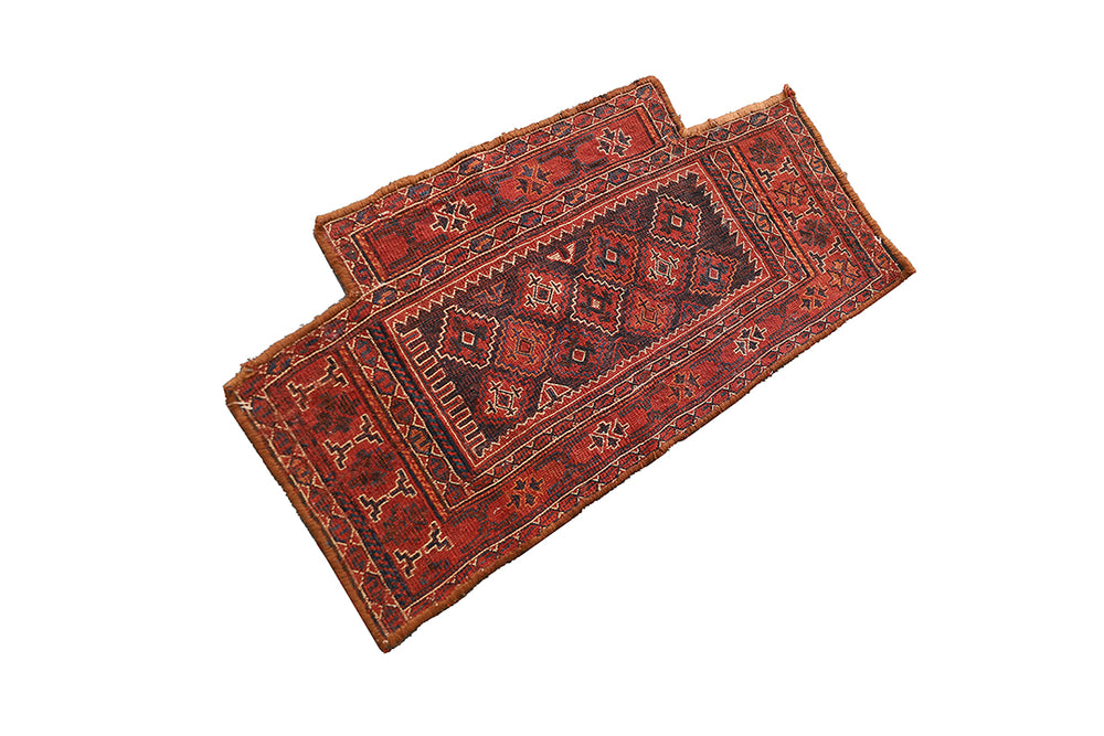 Two red patterned rugs on a white background