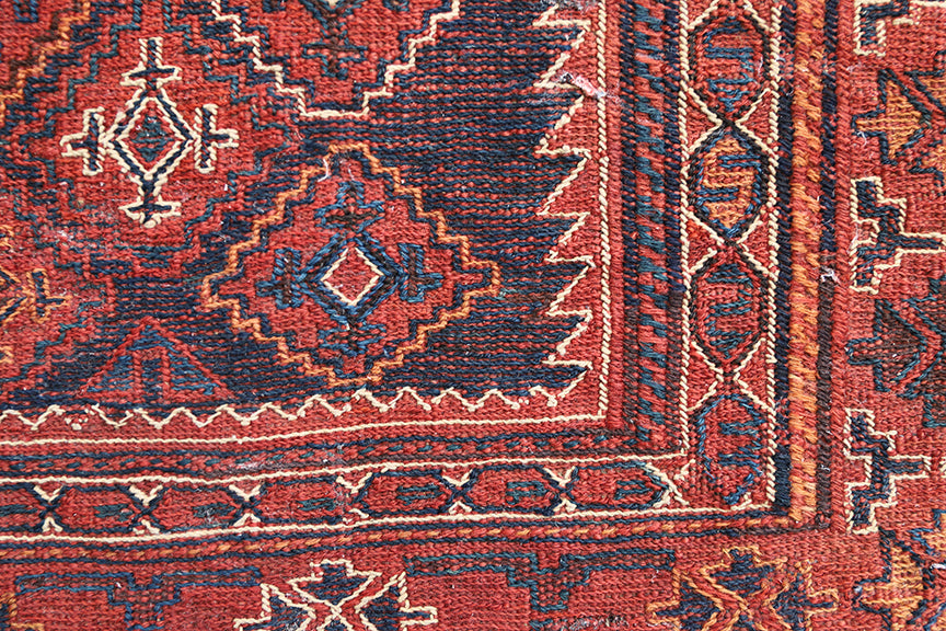 Close-up of a red and brown patterned rug corner