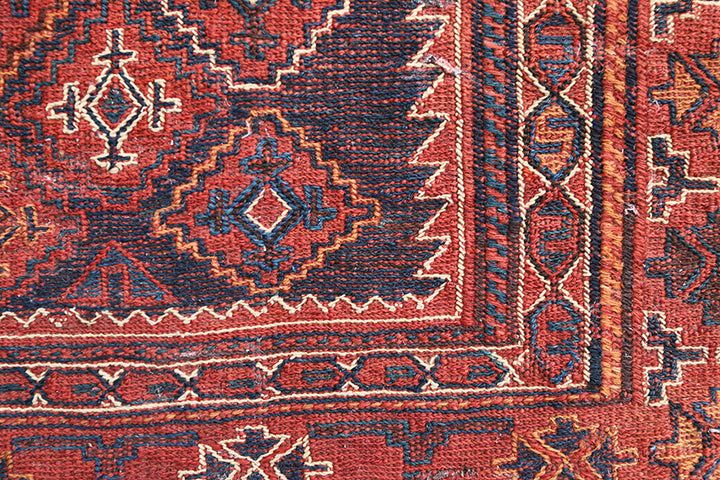 Close-up of a red and brown patterned rug corner