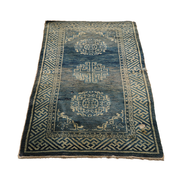 Vintage blue rug with intricate patterns on a white background