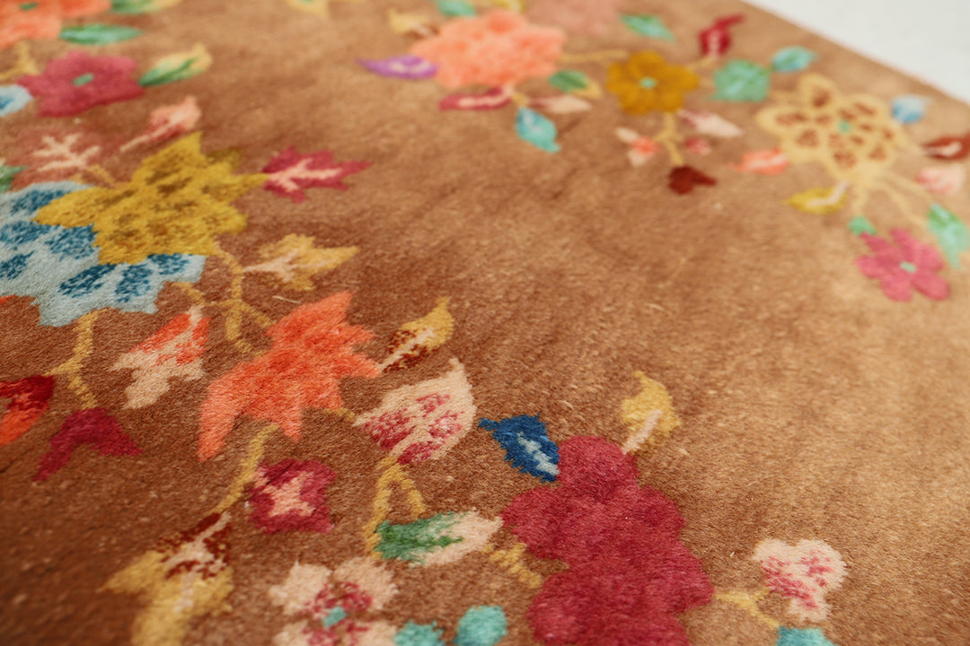 Close-up of a brown floral-patterned rug with colorful flowers.