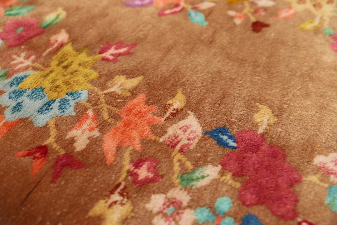 Close-up of a textured fabric with colorful floral patterns on a brown background