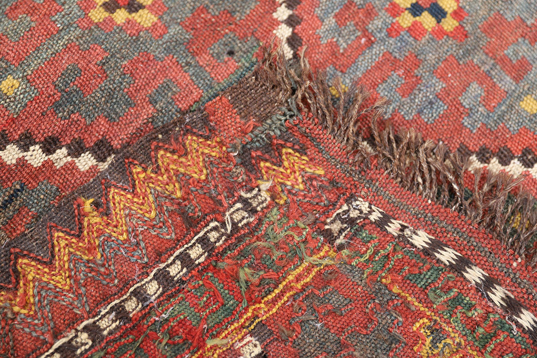 Close-up of a patterned rug with red, yellow, and black colors.
