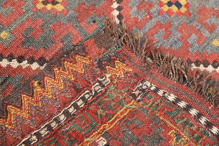 Close-up of a patterned rug with red, yellow, and black colors.
