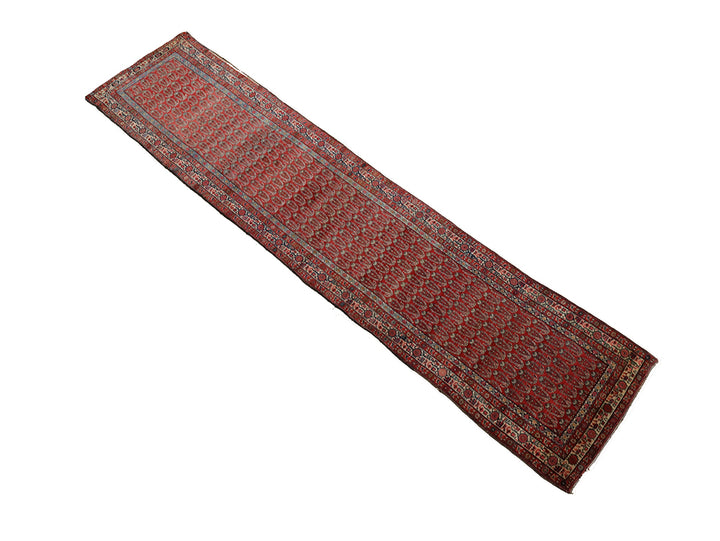 Antique Persian gallery runner (15'9" x 3'4") featuring a classic Paisley Boteh design on a red field with green, brown, and a wide white border.