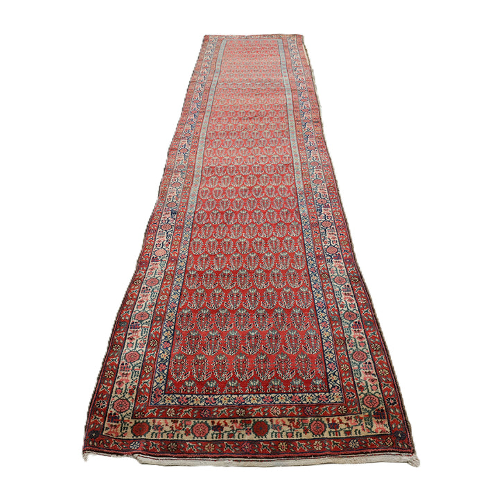 Antique Persian gallery runner (15'9" x 3'4") featuring a classic Paisley Boteh design on a red field with green, brown, and a wide white border.