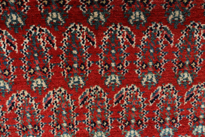 Antique Persian gallery runner (15'9" x 3'4") featuring a classic Paisley Boteh design on a red field with green, brown, and a wide white border.