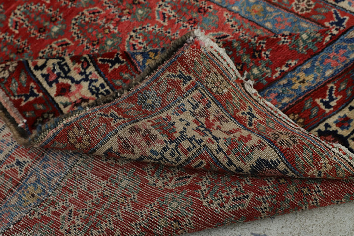 Antique Persian gallery runner (15'9" x 3'4") featuring a classic Paisley Boteh design on a red field with green, brown, and a wide white border.