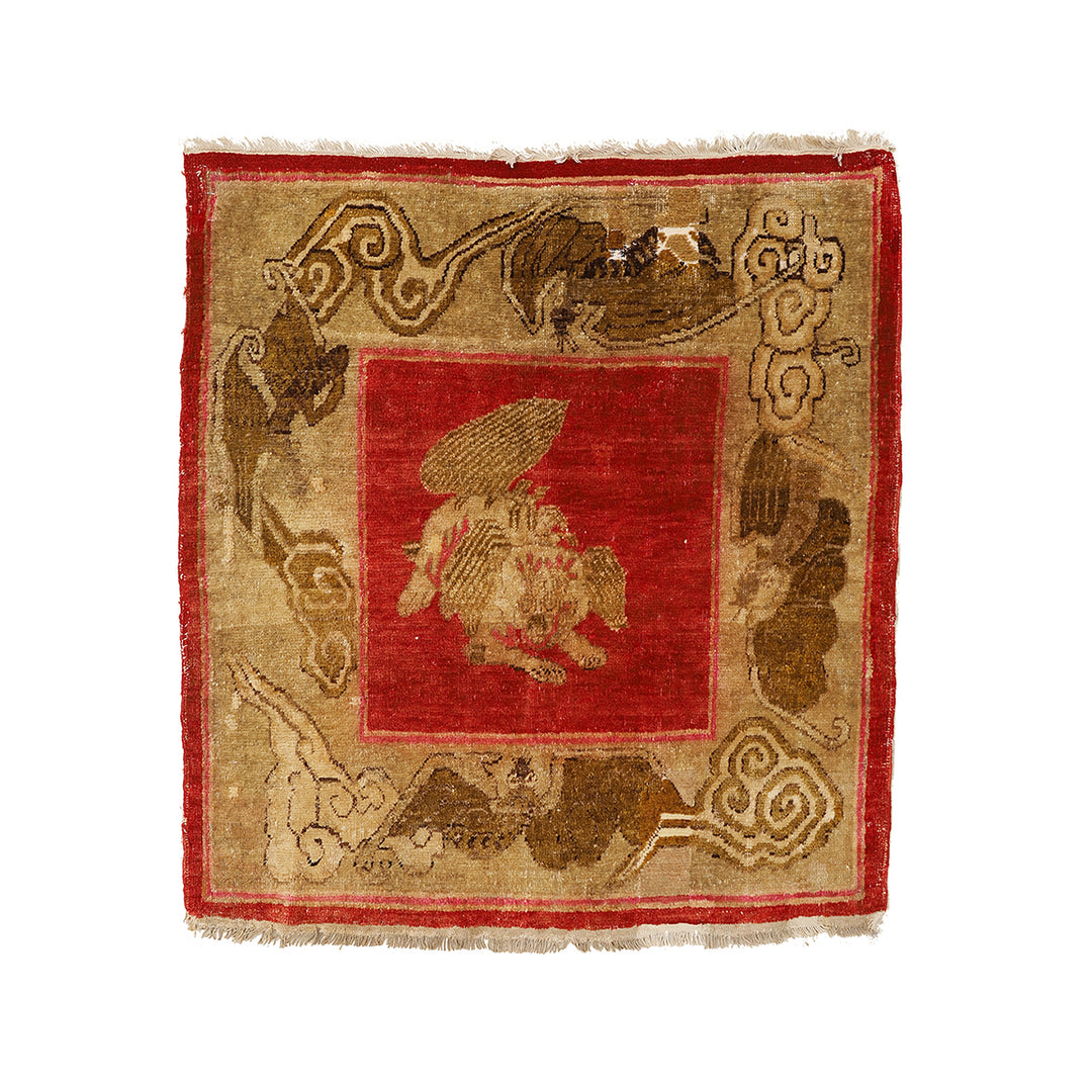 Decorative rug with central red square and intricate border design on a beige background