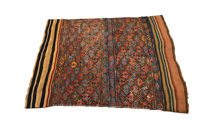 Traditional patterned fabric with vibrant colors on a white background