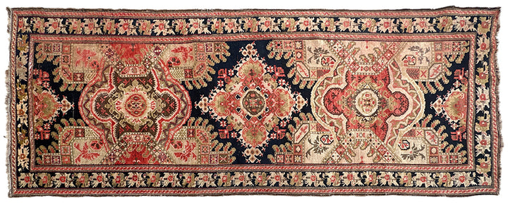 9'10" x 3'10" Antique Caucasian Karabagh wool runner rug featuring medallions and floral borders on a black background.
