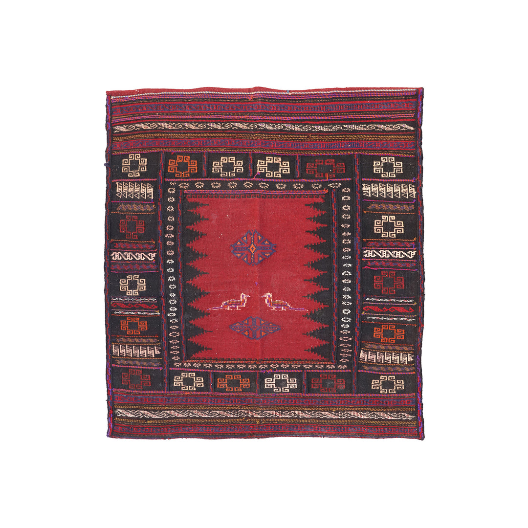 Traditional patterned rug with red and black colors on a white background