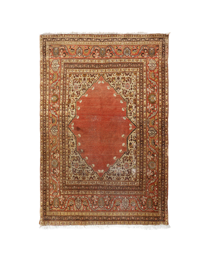 A traditional oriental rug with a central rust-red diamond medallion, surrounded by intricate floral motifs in beige, brown, and muted blue on a white background.