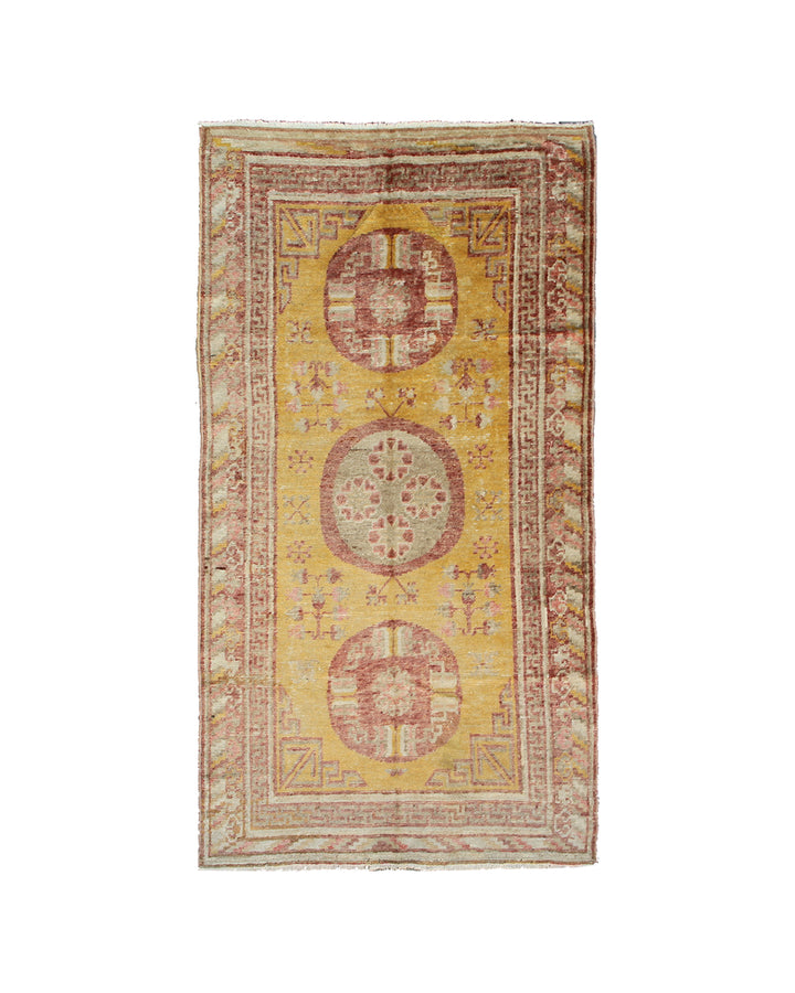 Vintage-style rug with circular patterns on a yellow background