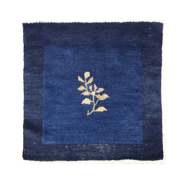 Blue rug with a gold leaf design on a white background