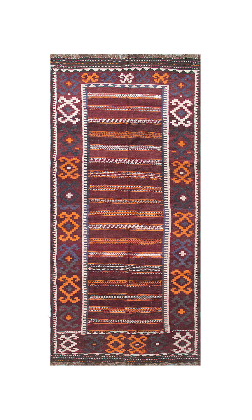 A rectangular kilim rug with a geometric pattern, featuring a central field of rust, orange, and brown stripes, bordered by dark red, orange, and cream geometric motifs on a white background.