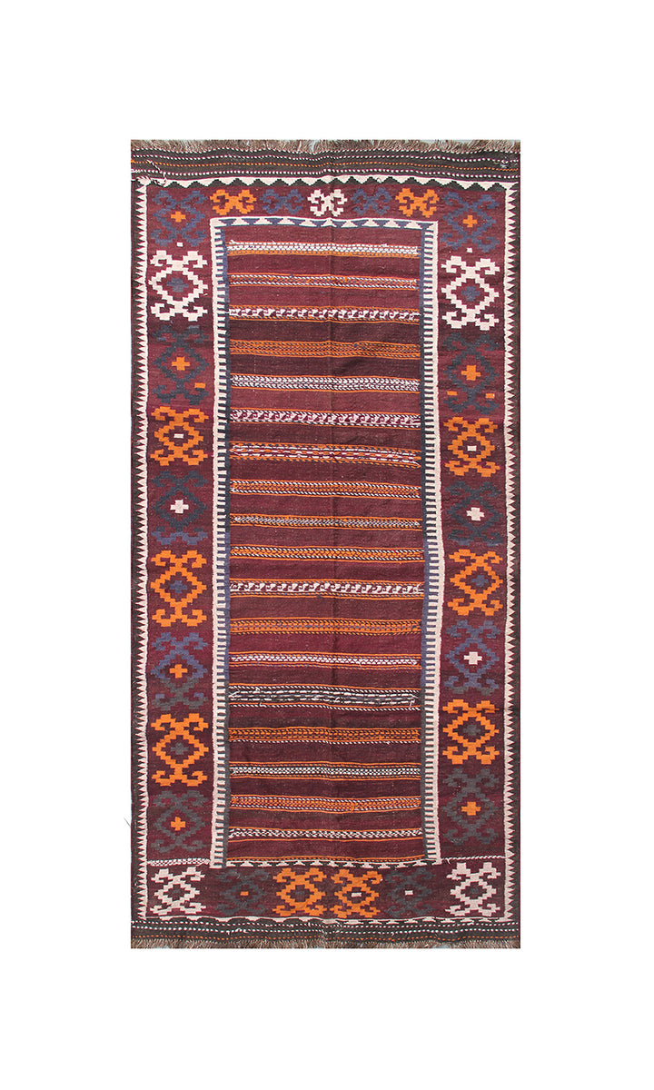 A rectangular kilim rug with a geometric pattern, featuring a central field of rust, orange, and brown stripes, bordered by dark red, orange, and cream geometric motifs on a white background.
