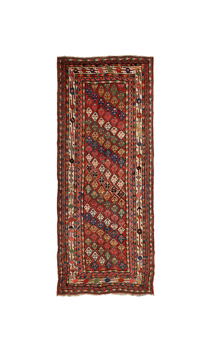 A rectangular vintage Persian runner rug with a complex geometric pattern in red, blue, green, and beige, isolated on a white background.