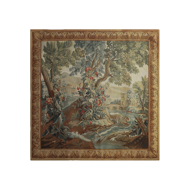 A square tapestry featuring a classic toile landscape scene with trees, a river, and a villa, framed by an ornate gold and brown border, shown against a plain white background.