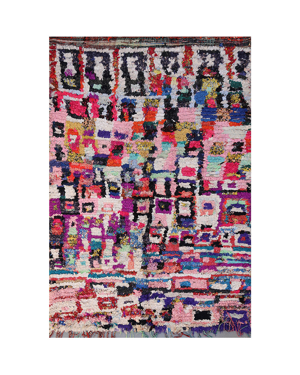 Multicolored geometric patterned rug on a white background