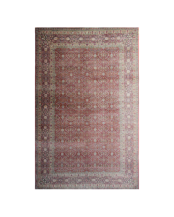 A rectangular traditional area rug with an intricate floral pattern, featuring a dusty rose center field, beige and cream borders, and a muted green outer border, shown flat against a white background.