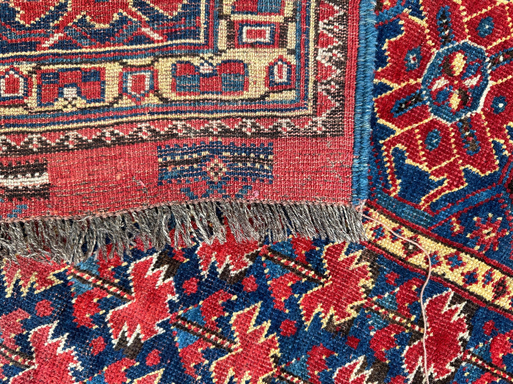 Close-up of a patterned rug with red, blue, and yellow colors.