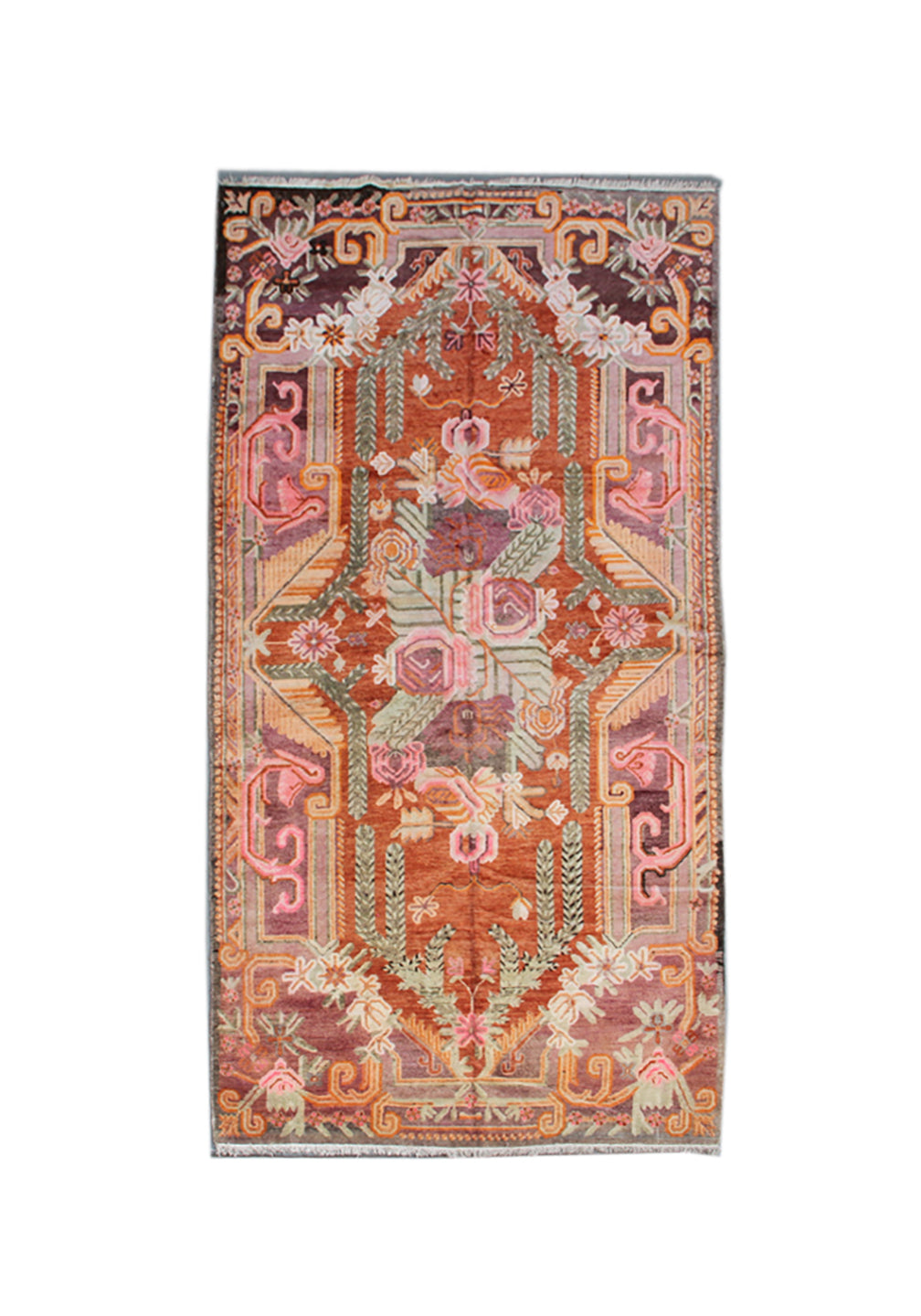 A rectangular vintage-style area rug with an intricate, symmetrical floral and geometric pattern in muted terracotta, dusty pink, sage green, and brown tones, shown flat against a white background.
