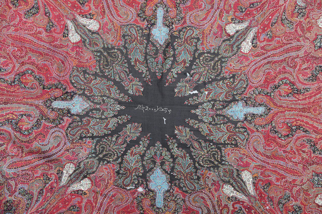 Close-up of a patterned fabric with red, black, and white colors.