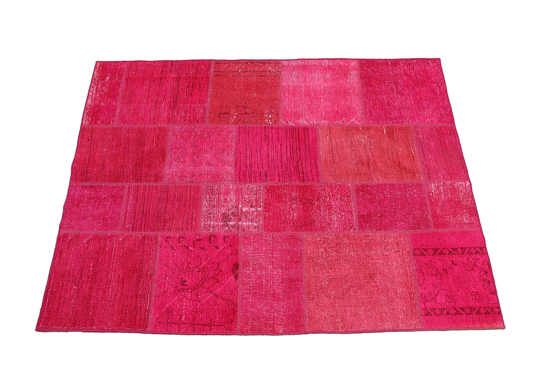 Pink patchwork rug on a white background