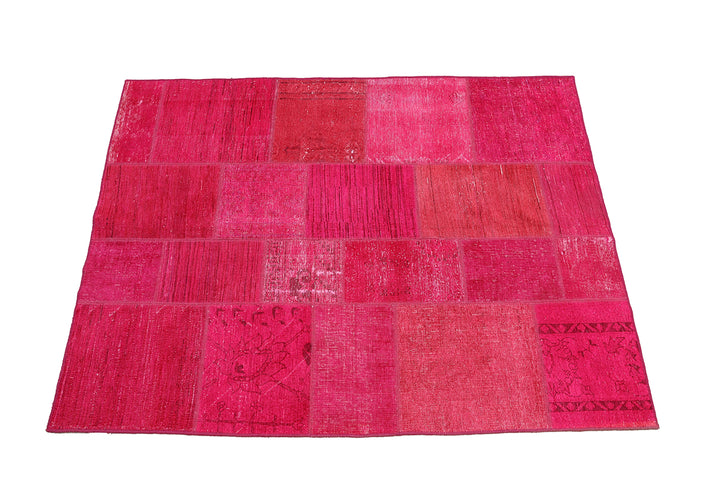 Pink patchwork rug on a white background